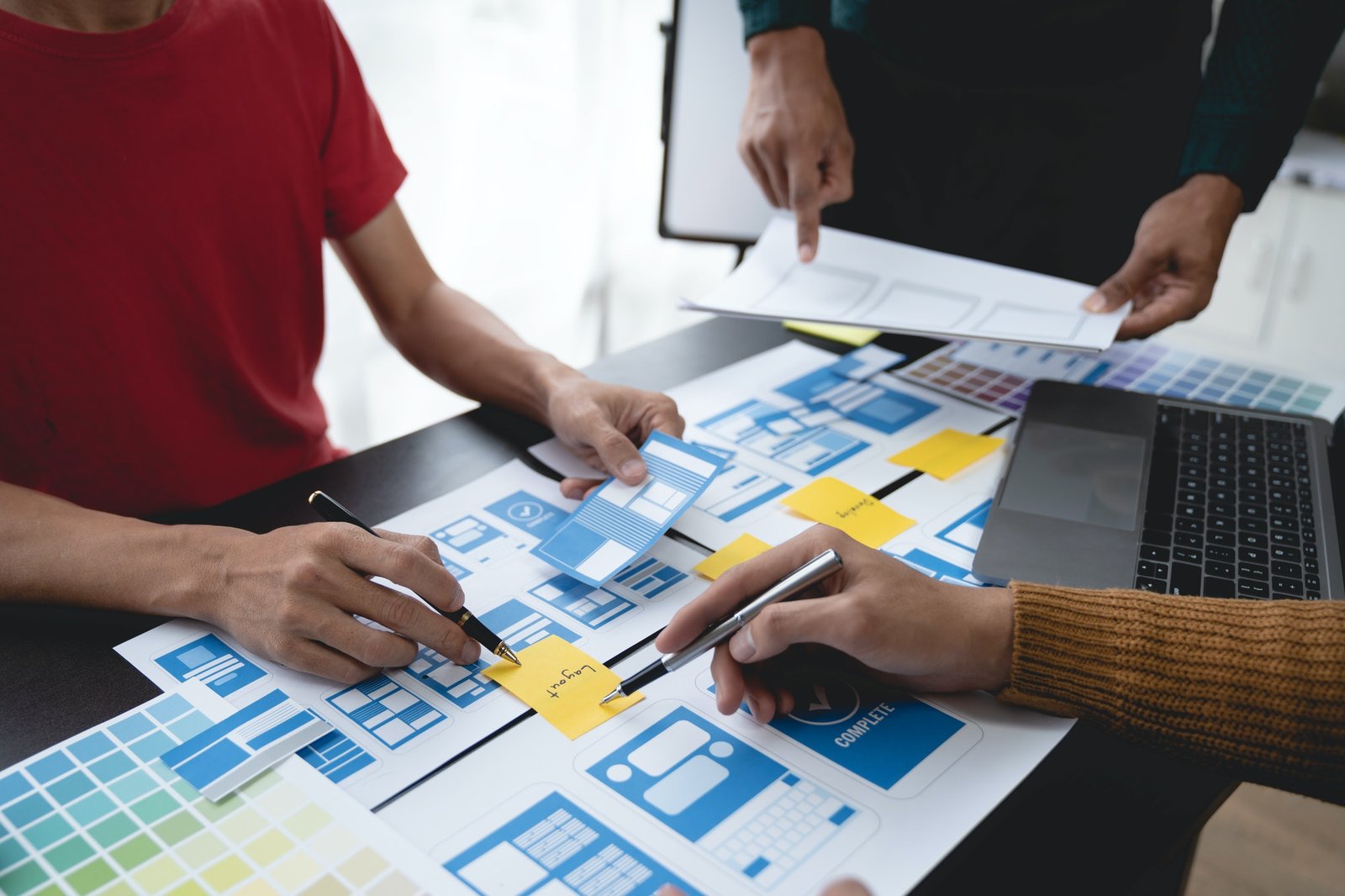 ux developers, UI designers Asian group data researchers brainstorm on tabletop mobile app interface